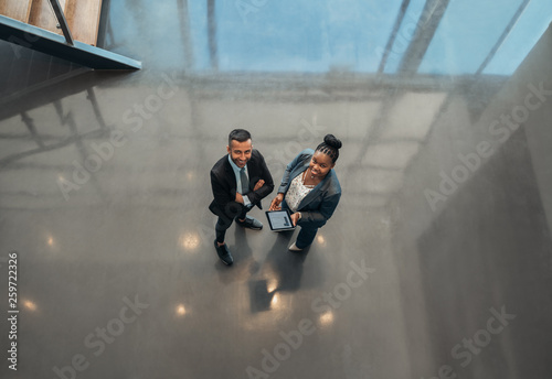 Wallpaper Mural Two business people standing in the lobby of an office looking up smiling at the camera while Torontodigital.ca