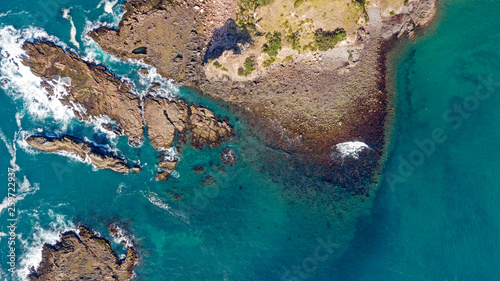 aerial shot of waves hitting rocks © ManHin