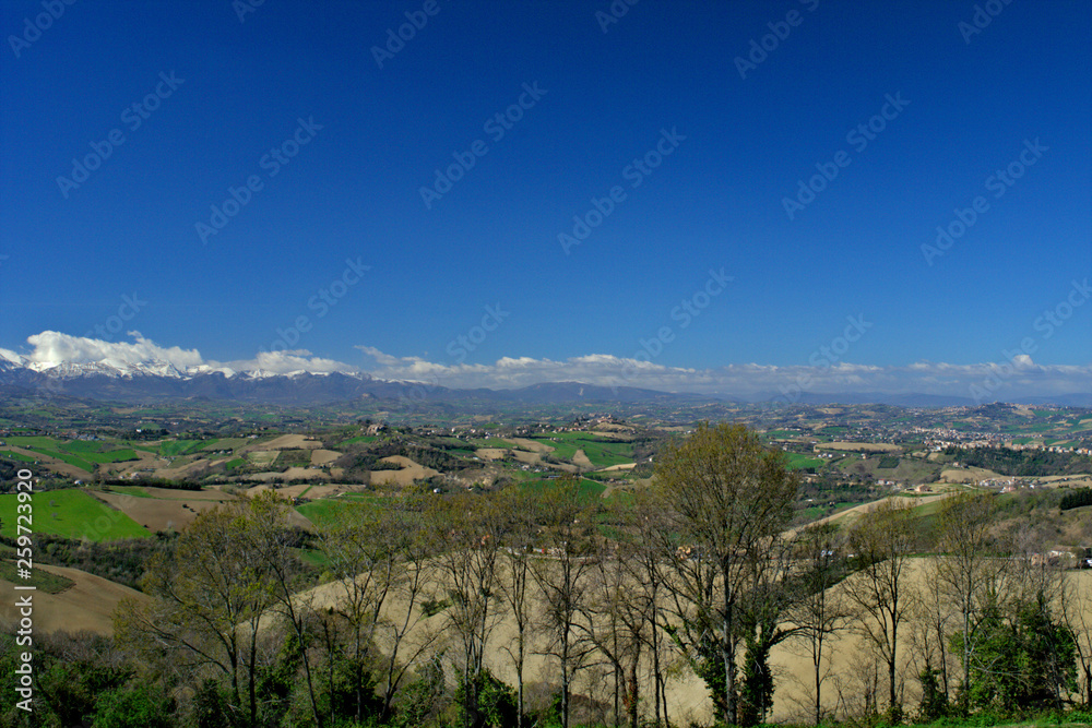 view of mountains,countryside,italy,landscape,horizon,rural,spring,clouds,tourism,travel,tree,panorama