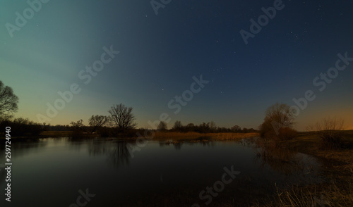 Stars in the night sky over the river. Early spring in central Russia.
