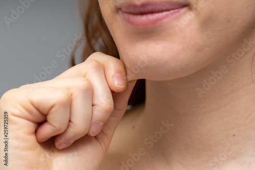 Closeup view of a Caucasian woman pinching the fat beneath her chin photo