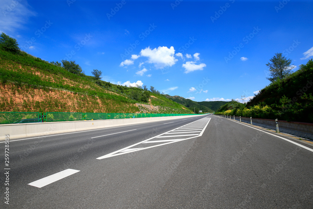Highway, under the background of blue sky and white clouds Highway, under the background of blue sky and white clouds