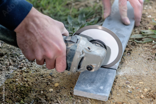 Tiler cutting a stone tile using an angle grinder