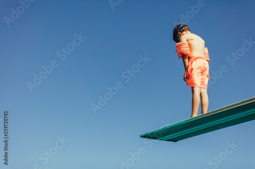 Bild auf Leinwand Boy learning on diving spring board