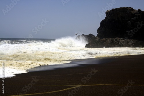 White breakwater foam hit on lonely black lava sand beach at Pacific coastline - Cobquecura Piedra De La Loberia  Chile