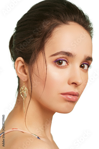 фотографія Closeup portrait of a pretty lady with lilac eyeshadows and dark brown hair, wearing stylish long earrings