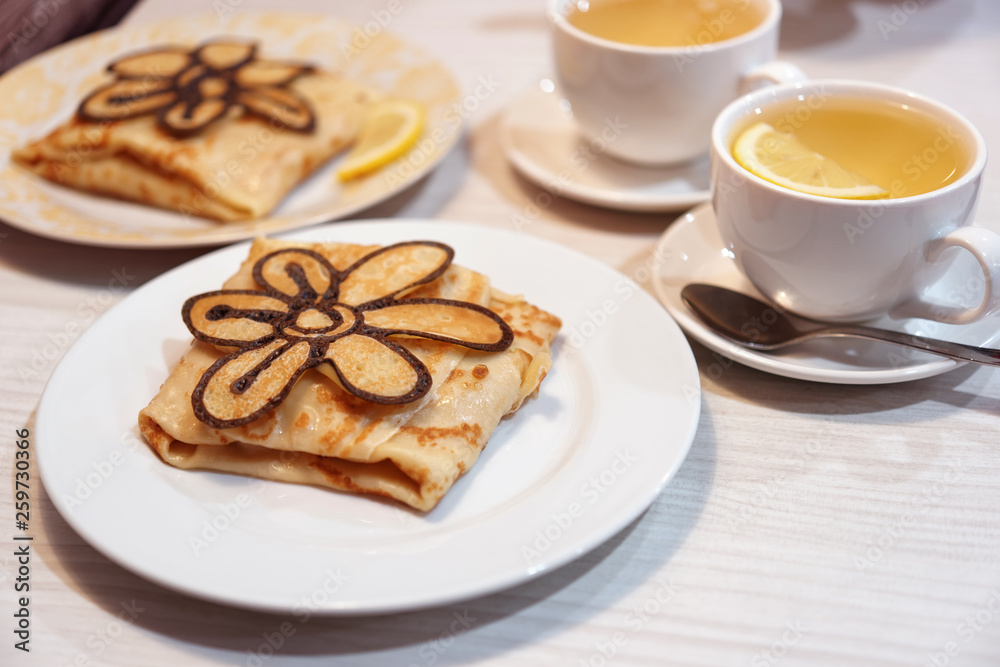 Russian crepes decorated with baked flower with tea Russian crepes decorated with baked flower with tea