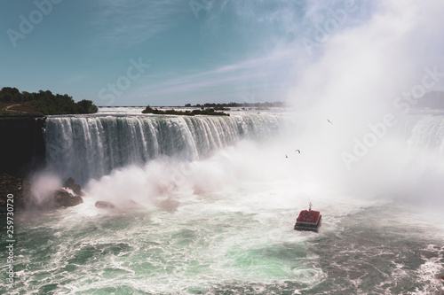 Niagara Falls famous Tour Boat under Horseshoe Waterfall in summer. Horseshoe Fall lies on the border of the United States and Canada
