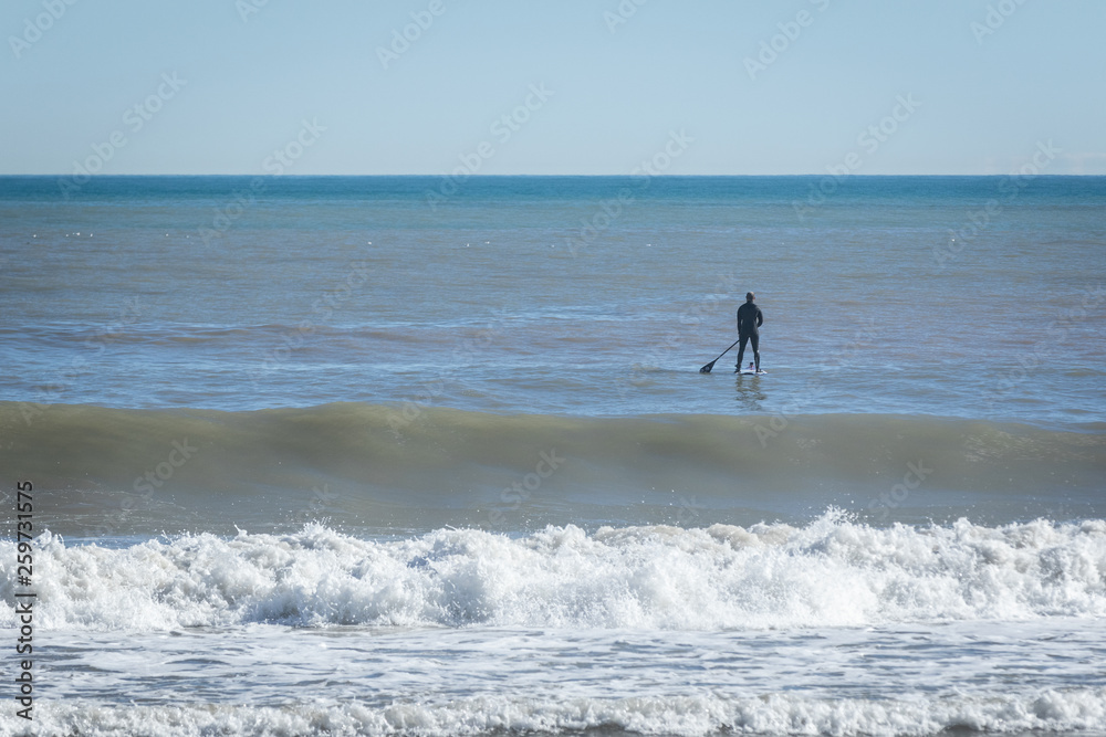 Surfer with paddle board catching the wave. Surfer with paddle board catching the wave.