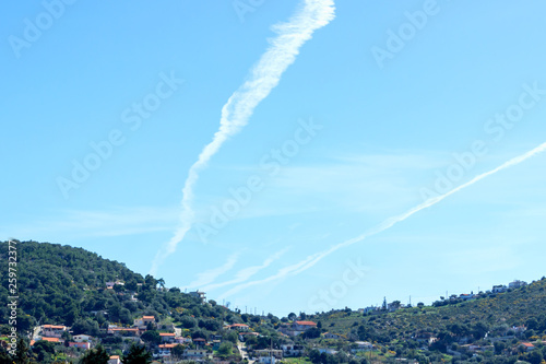 Trace of the plane in the blue sky. Sunny day. Greece. Concept- travel, vacation, geoengineering and chemtrails.