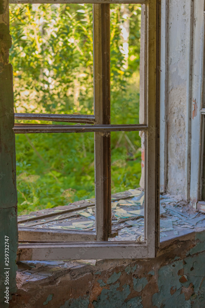 Fototapeta premium white lit vintage, old window in an ancient white brick wall in an abandoned castle, interior with light from the windows, old windows with empty frame, green grass