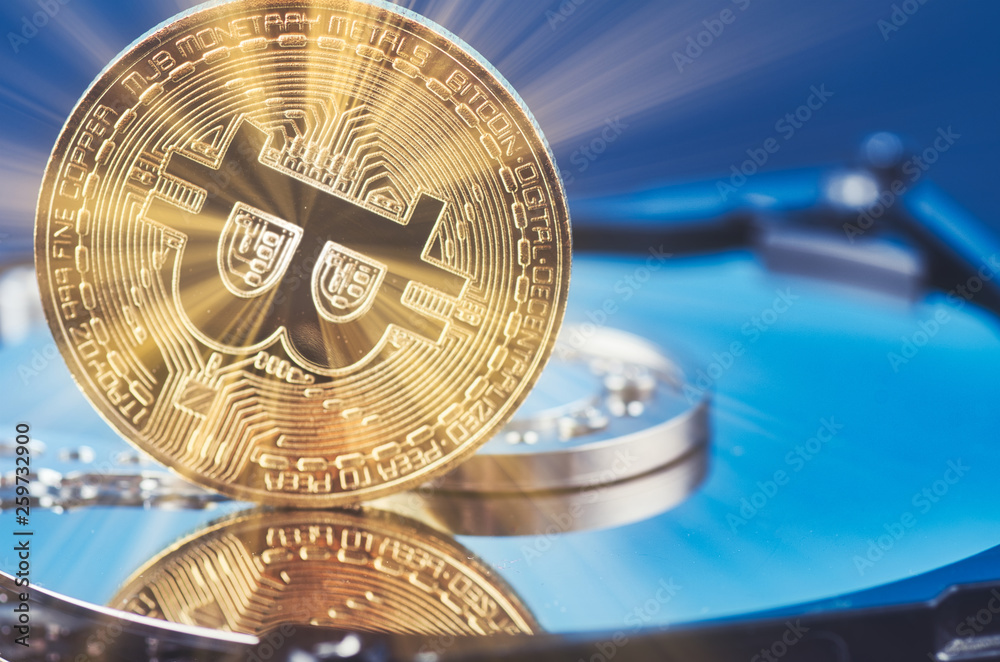 Virtual Cryptocurrency and Blockchain Technology concept, golden bitcoin on dismantle hard disk over gently lit dark background and light ray Virtual Cryptocurrency and Blockchain Technology concept, golden bitcoin on dismantle hard disk over gently lit dark background and light ray