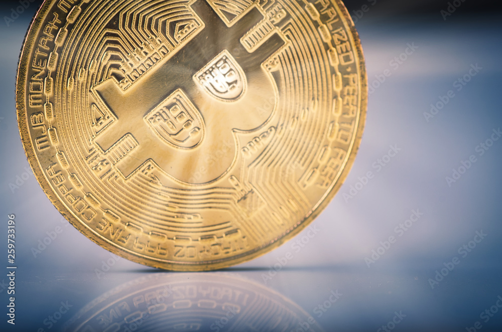 Virtual Cryptocurrency and Blockchain Technology concept, golden bitcoin on reflection table over gently lit dark background and light ray