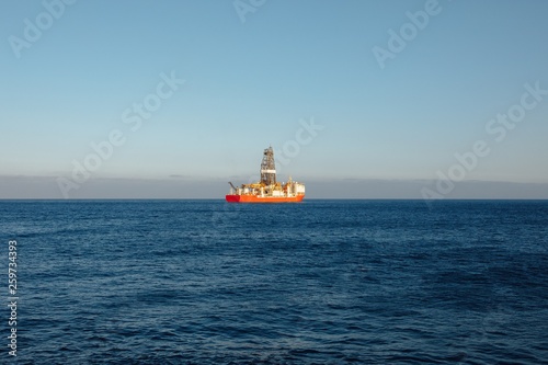 offshore oil and gas drillship, blue ocean background © nikkytok