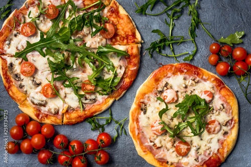 Homemade pizza with rucola and cherry tomatoes.