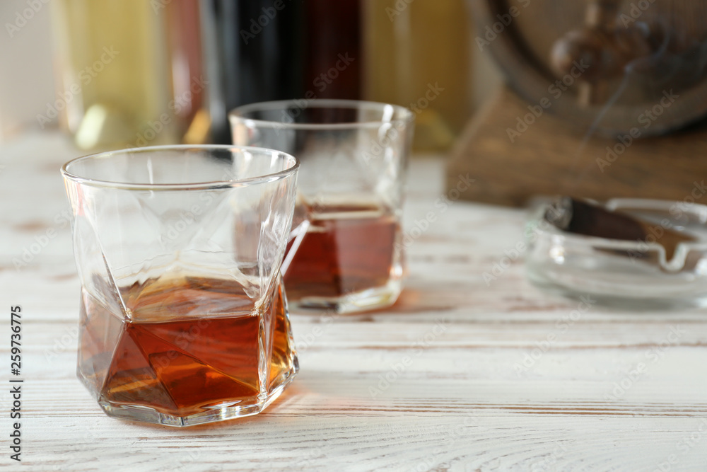 Glass of cold whiskey on white table Glass of cold whiskey on white table