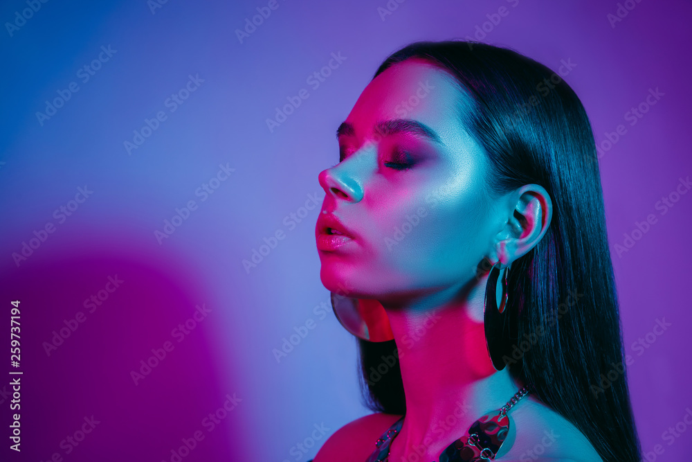 High fashion model in colorful bright neon lights posing at studio. Portrait of beautiful girl with trendy glowing make-up. Art design vivid style. High fashion model in colorful bright neon lights posing at studio. Portrait of beautiful girl with trendy glowing make-up. Art design vivid style.
