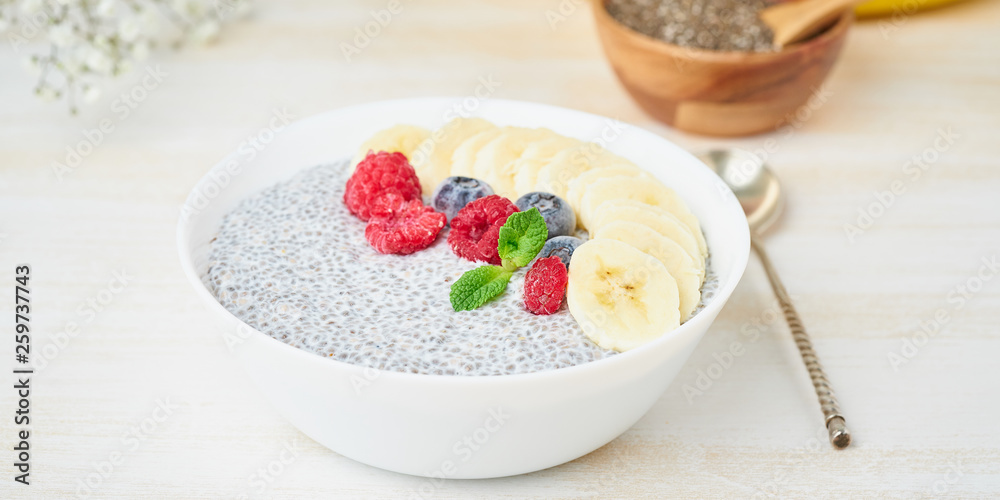 Banner with Chia pudding in bowl with fresh berries raspberries, blueberries. Side view, white wooden light background. Banner with Chia pudding in bowl with fresh berries raspberries, blueberries. Side view, white wooden light background.