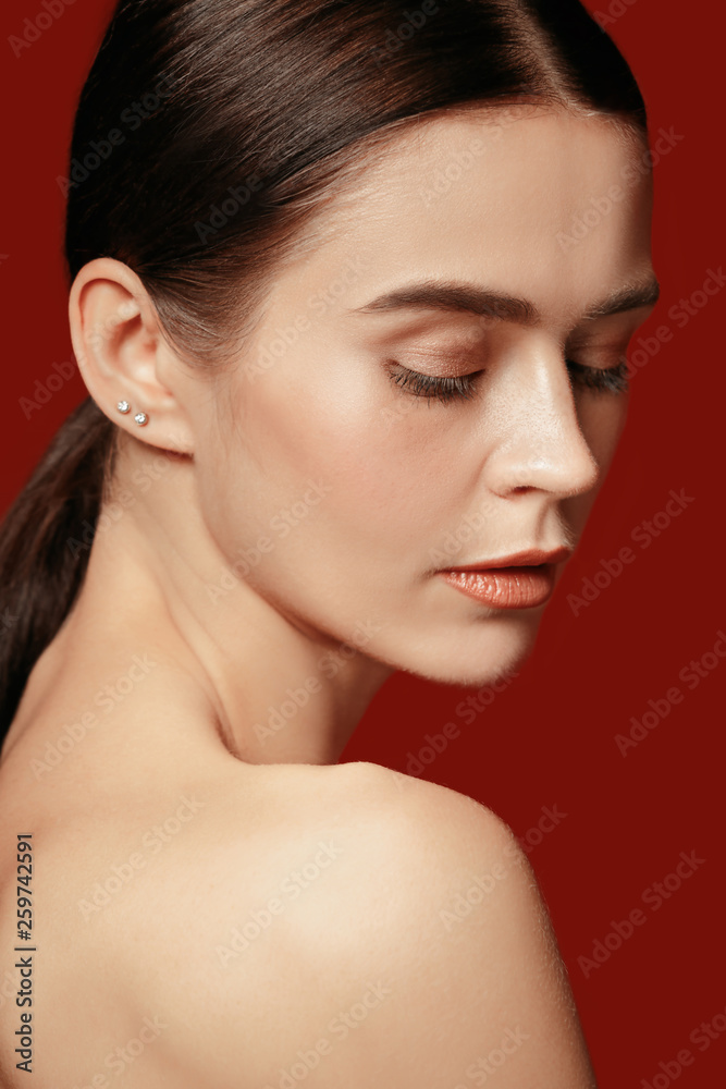 A beautiful female face. Perfect and clean skin of young caucasian woman on red studio background. A beautiful female face. Perfect and clean skin of young caucasian woman on red studio background.
