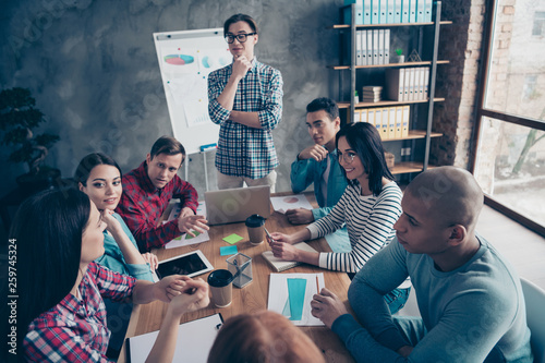 Company of nice stylish attractive beautiful handsome specialists wearing casual sitting talking new financial growth career promotion at industrial interior workplace workstation