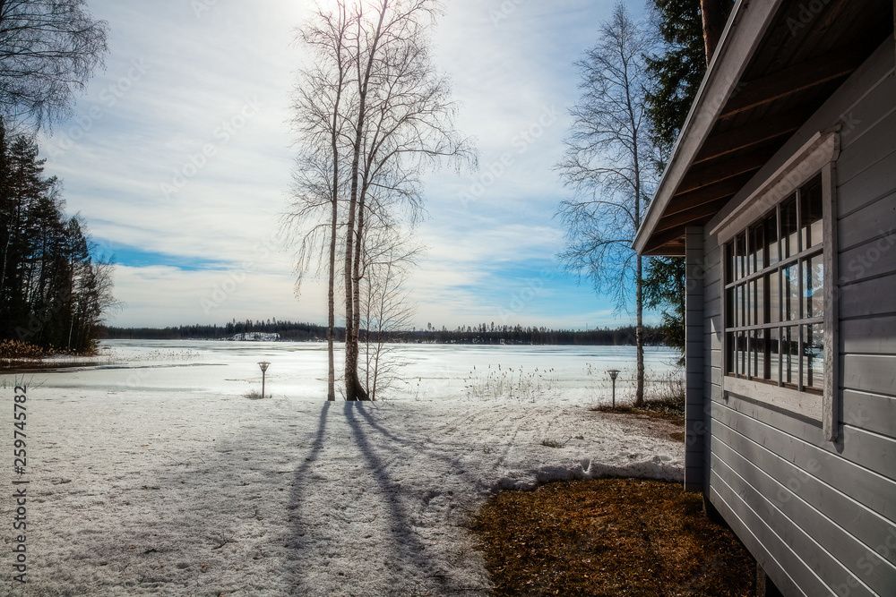 Winter landscape - House stand by the lake on a Sunny day