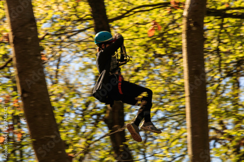 Parcours d'Accrobranche en forêt avec personne en action