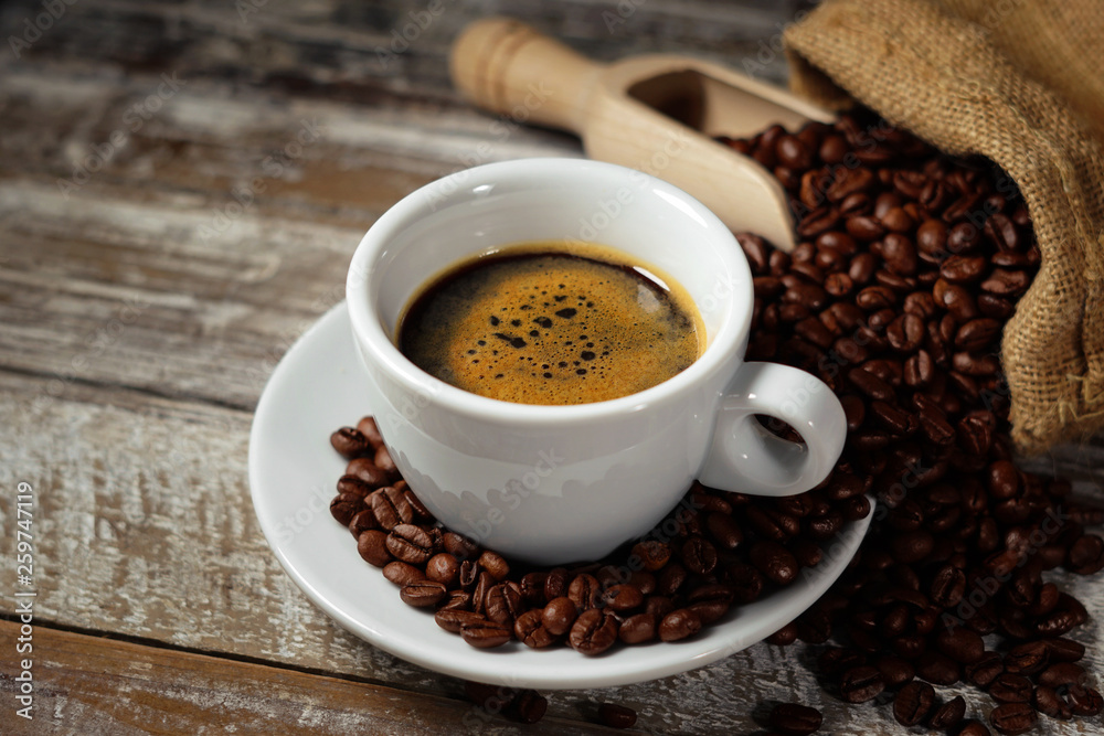 Coffee Cup And Coffee Beans On Rustic Table Coffee Cup And Coffee Beans On Rustic Table