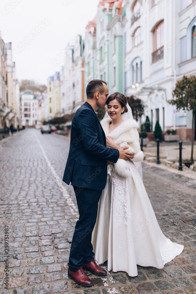 Romantic walk of the groom and the bride through the streets of the city.