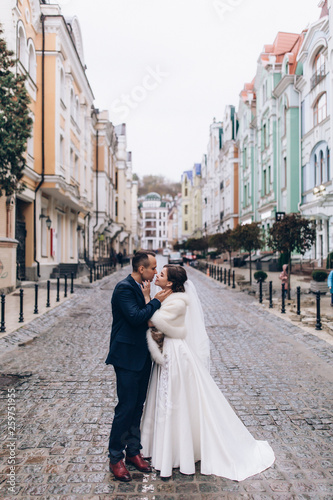 Romantic walk of the groom and the bride through the streets of the city. © dimadasha