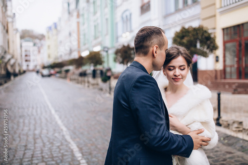 Romantic walk of the groom and the bride through the streets of the city.