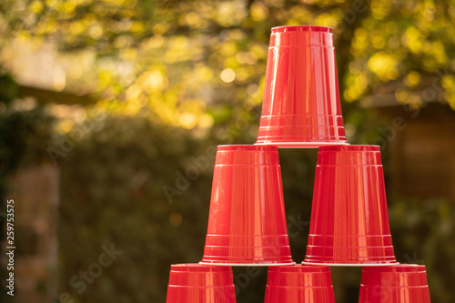 Fotografie Plastic red solo drinking cups for beer pong or drinking games with green background on a white table