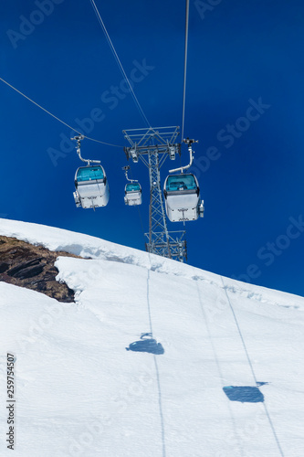 Gondola lift ( cable car ) with tower and station over snow of mountain alps, transpotation from grindelwald to First peak Switzerland Europe