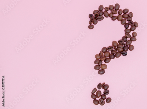 The coffee beans in shape of question mark, isolated on pink background