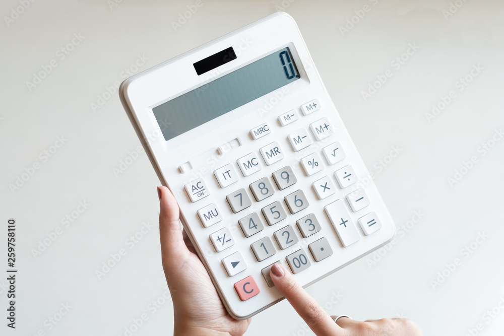 Businesswoman using a white calculator to calculate the value of business financial - obrazy, fototapety, plakaty 