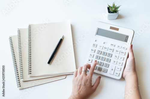 фотографія Businesswoman using a white calculator to calculate the value of business financ