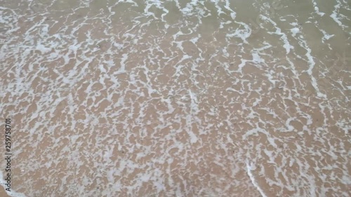 Aerial view of sea waves crashing against the beach