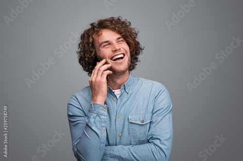 Cheerful male speaking on smartphone