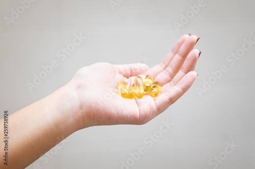 Yellow pills in woman's hand