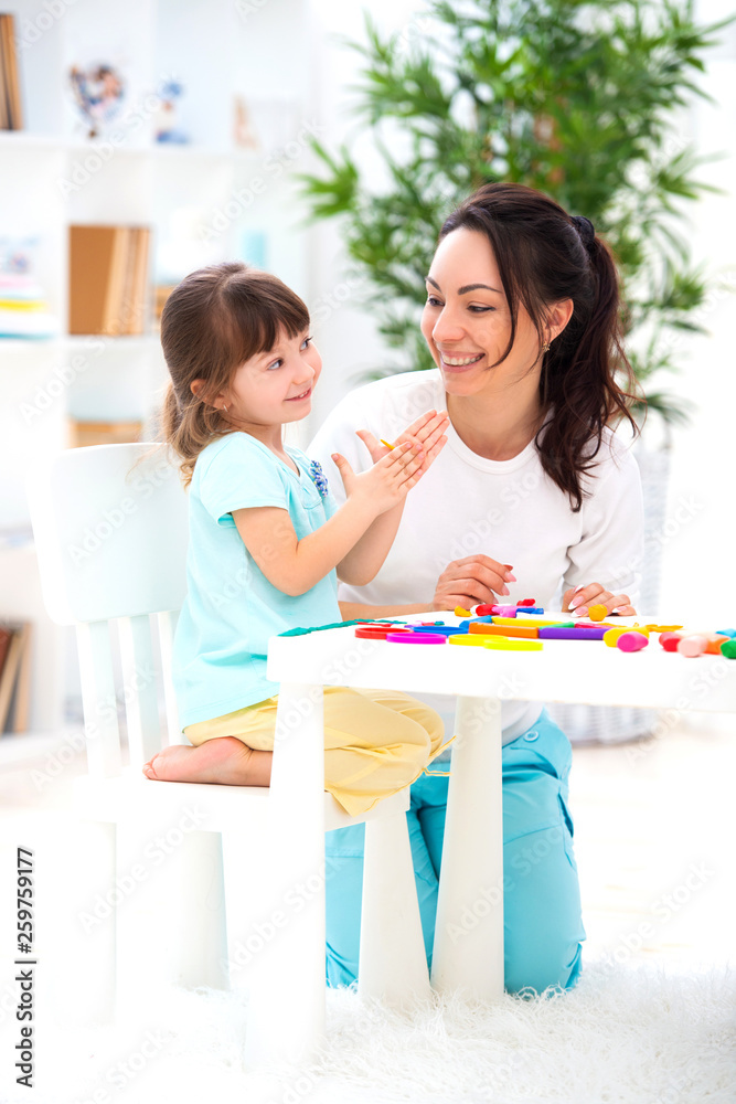 Smiling mother helps a little daughter to sculpt figurines from plasticine. Children's creativity. Happy family Smiling mother helps a little daughter to sculpt figurines from plasticine. Children's creativity. Happy family