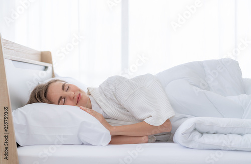 Beautiful young woman happy to sleeping in bed comfortably