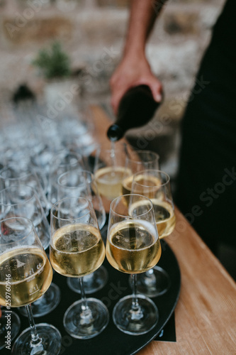 Sommelier pouring white wine in glasses at a restaurant table, 