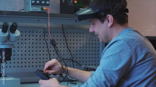 The worker checks the performance of the device. Connects the wires, adjusts the scan tool