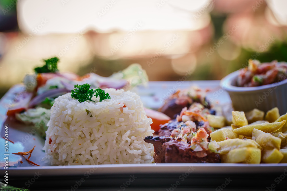 steak served in a restaurant dish with frites and rice steak served in a restaurant dish with frites and rice