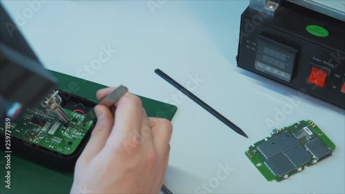 Electronic lab working place with soldering iron and circuit board. Electronics repair and fix service concept