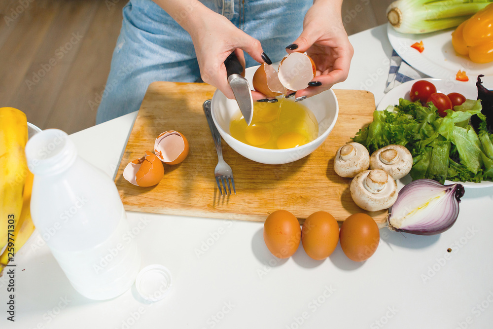 One young pretty woman prepares an omelette. One young pretty woman prepares an omelette.