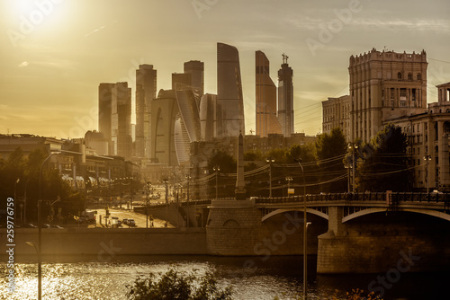 Sunny view of Moscow with skyscrapers of Moscow-City, Russia. Panorama of modern tall buildings and old Borodinsky bridge in the Moscow center in summer. Beautiful cityscape of Moscow in sun light. photo