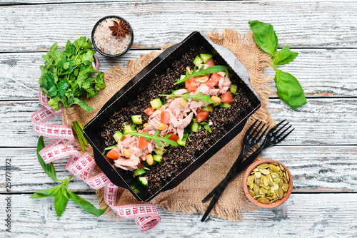 Quinoa with Tuna and Vegetables. Food with delivery. Top view. Free space for your text. Rustic style. photo