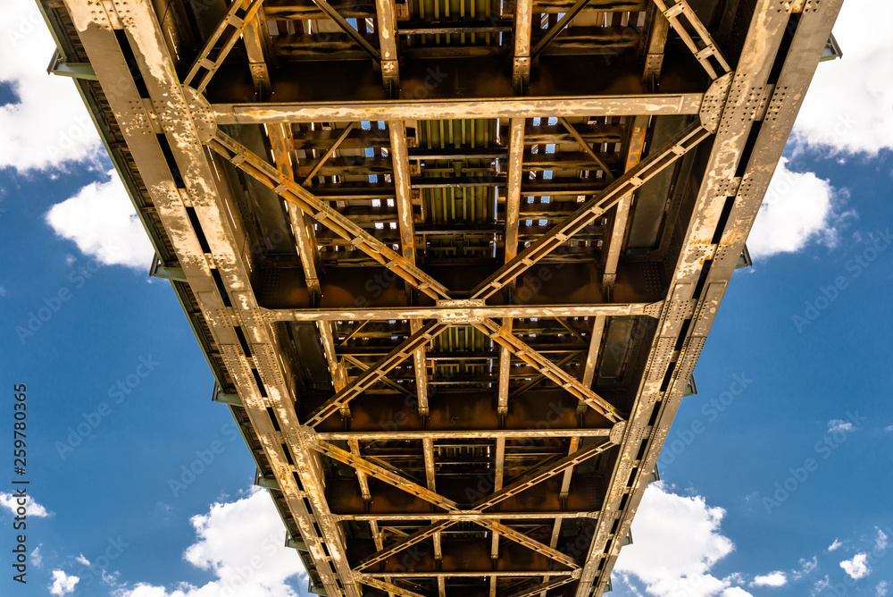 Steel lattice construction of a railway bridge on a background of blue sky with white clouds. Steel lattice construction of a railway bridge on a background of blue sky with white clouds.