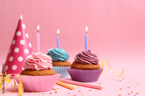 Delicious cupcakes with candles on a colored background. Festive background  birthday