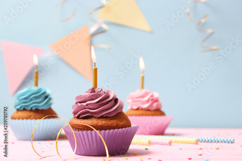 Delicious cupcakes with candles on a colored background. Festive background  birthday